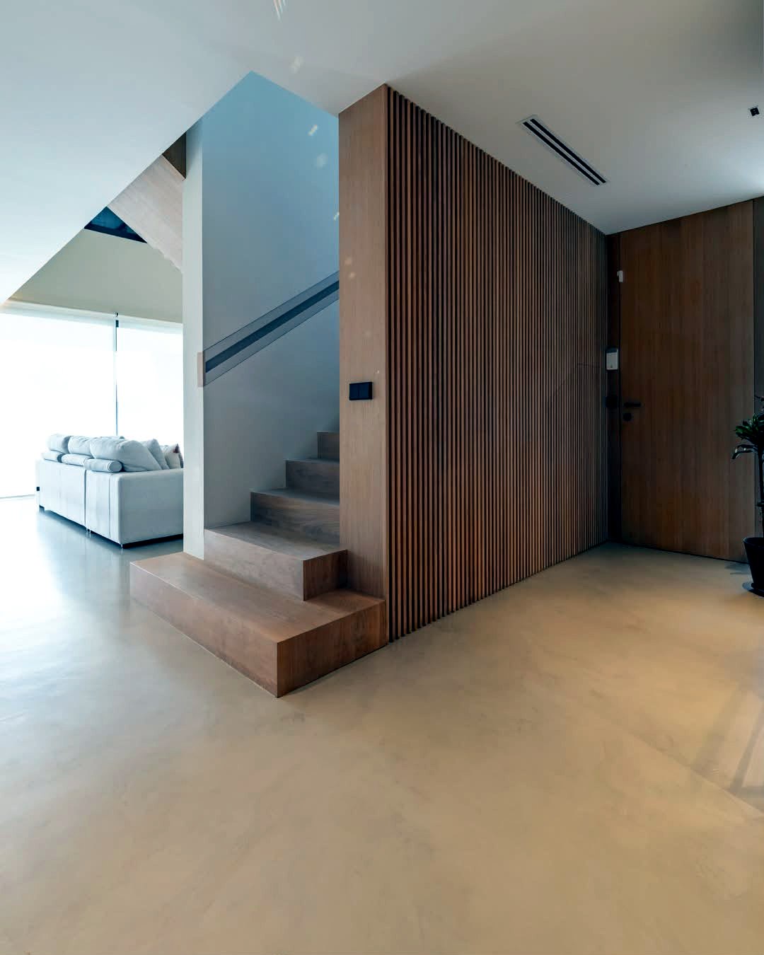 Hallway and staircase finished in seamless cream microcement flooring, residential renovation UK